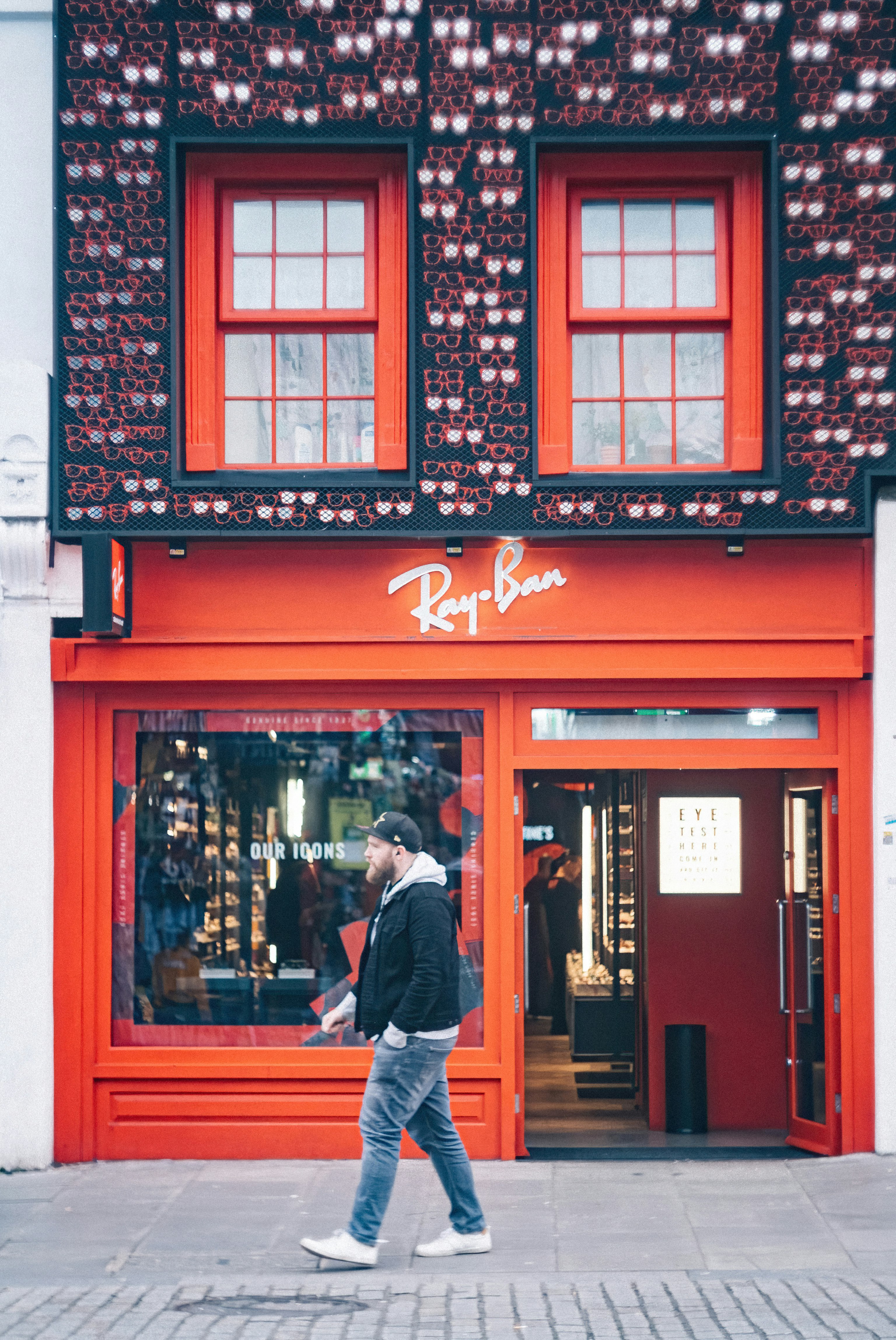 man in black jacket standing in front of store